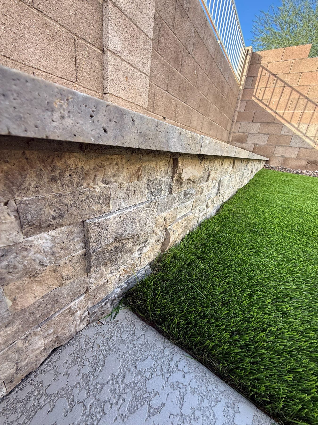 Stacked stone retaining wall with travertine cap